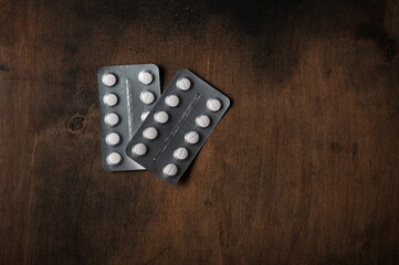 tablets in a blister pack on a wooden table.