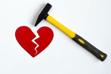 a hammer breaking a red heart on white background