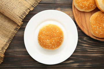Hamburger buns in plate on brown background