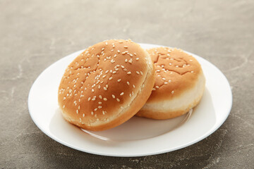 Hamburger buns in plate on grey background