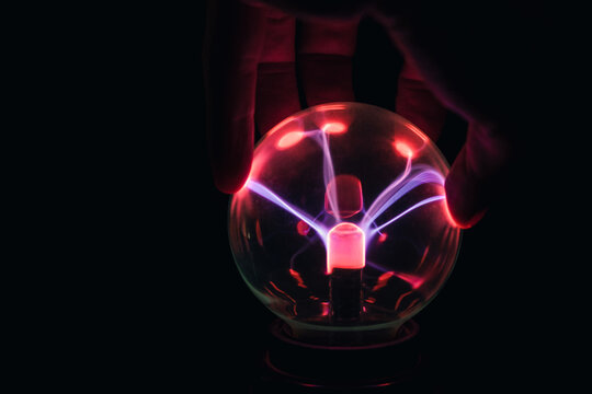 hand touches the plasma ball. electrical impulses, living electricity