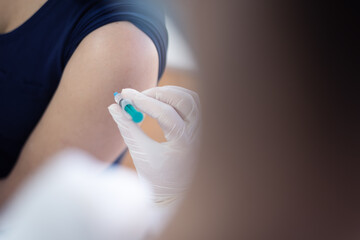 Close up of a Doctor making a vaccination in the shoulder of patient, Flu Vaccination Injection on Arm, coronavirus, covid-19 vaccine disease preparing for human clinical trials vaccination shot.