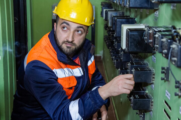 electrician with yellow helmet working in a power station