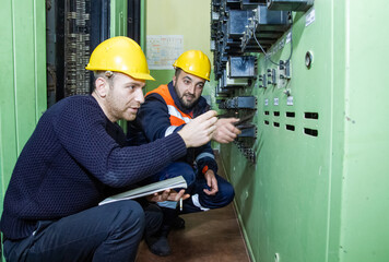 electricians with yellow helmet working in a power station