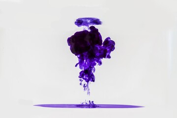 Purple ink drop in water white background