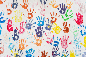 White wall with colorful multicolored hand prints. - 408636002