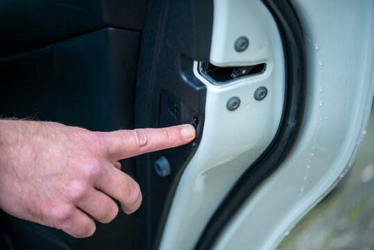 The Father Press Lock Button On Rear Door To Prevent Children From Open The Door From Inside The Car. Safety Traveling Concept.