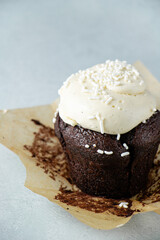 Chocolate cupcakes with buttercream frosting and white sprinkles