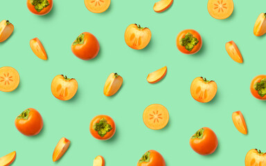 Colorful fruit pattern of fresh persimmon fruit on green background