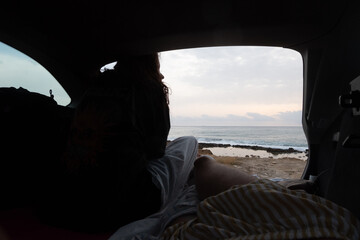 girl looking at the sea from a camper car