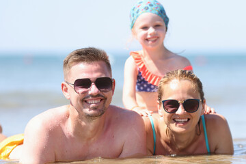 Obraz premium Married couple with child spend time at sea. Family travel to resorts concept