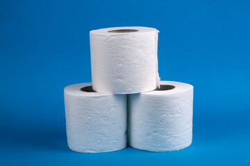 Three rolls of toilet paper on a blue background.