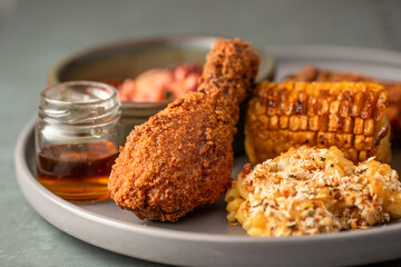 Southern fried chicken with mac and cheese, corn on the cob, coleslaw and maple syrup sauce