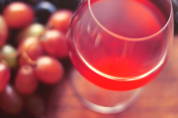 Glass of wine, bottle, grapes on a background of boards.