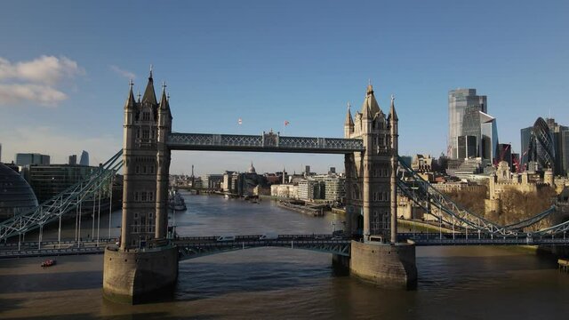 Afternoon Aerial drone shot taken in winter 2021showcasing the skyline of london business center the River Thames and passing above tower bridge.