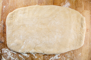 Raw cinnamon roll dough being prepared ready for baking