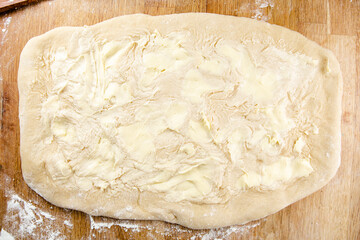 Raw cinnamon roll dough being prepared ready for baking