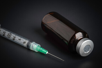 Disposable Injection And Amber Color Vial On Black Background