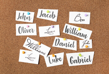 Paper pieces with baby names on cork board