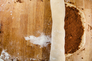 Raw cinnamon roll dough being prepared ready for baking