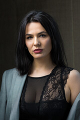 Naklejka premium Portrait of a young sexy brunette girl in a lace top in dramatic tones. Vintage photo.
