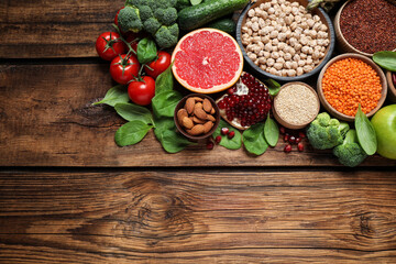 Fresh vegetables, fruits and seeds on wooden table, above view. Space for text