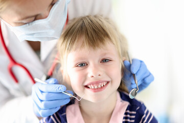 Portrait of smiling girl at dentist appointment. Treatment of baby milk teeth concept
