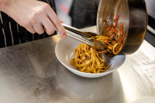 Chef Plating Up A Spicy Beef Ragu Tagliatelle 