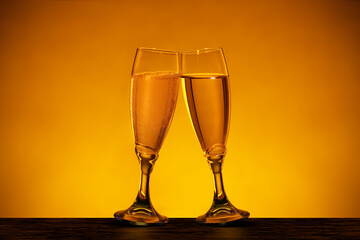 Due calici di champagne inclinati in un’atmosfera dorata
