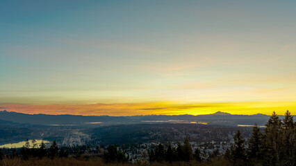 Sunrise over Fraser Valley, Port Moody, Burnaby and Burrard Inlet, BC with mountains on horizon

