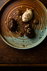 Chocolate, white chocolate and caramel ice cream quenelles on a colourful, rustic plate