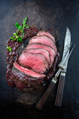 Traditional English venison roast with spicy sauce served as top view on a rustic board - obrazy, fototapety, plakaty