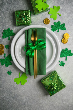 Beautiful festive table setting for St.Patricks day with cutlery and lucky symbols. Copy spase in center. Flat lay.