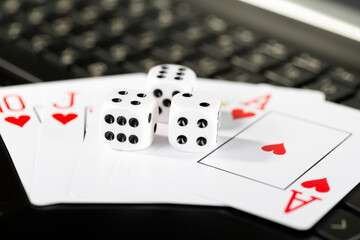 Online gaming platform, casino and gambling business. Cards and dice on laptop keyboard