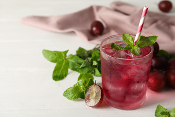 Delicious grape soda water with mint on white table. Refreshing drink