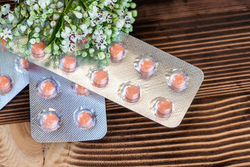 Fresh (Valeriana officinalis) flowers and Pills valerian on wooden background. Used as an...
