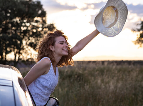 woman with curly hair wearing a hat in a lavender field