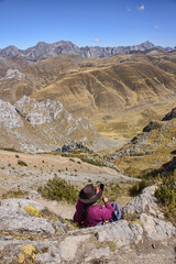 A Cholita enjoying the views from the Cancanapunta pass on the Cordillera Huayhuash circuit, Ancash, Peru 