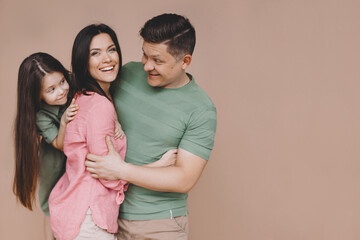 Fototapeta premium Parents with daughter hugging