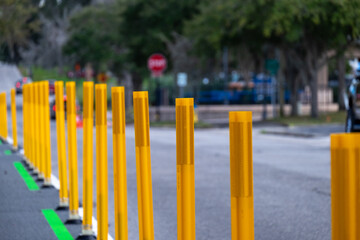 A row of bright yellow metal sticks used as barricades at a road construction barrier site. The...