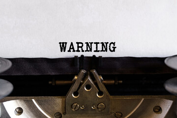 Vintage typewriter with typed text - WARNING, on a sheet of paper