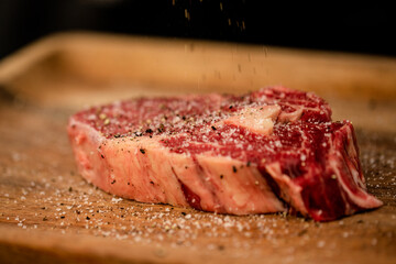 meat on a cutting board being seasoned