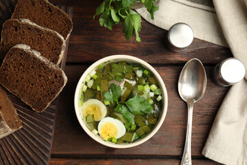 Delicious sorrel soup with eggs served on wooden table, flat lay