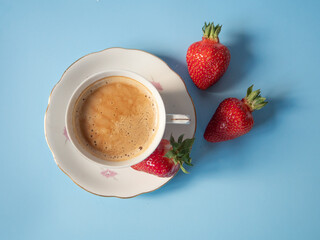 Coffee and strawberries on a blue background
