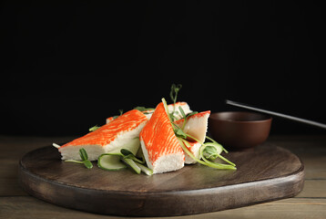 Fresh crab sticks with cucumber and soy sauce served on wooden table