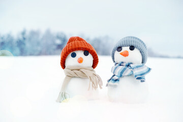 Festive background with a lovely snowman. Christmas card with two little snowmen the girl and the...