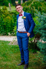 Portrait of smiling groom wearing red bow tie and blue jacket