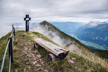 Ruhebank und das Gipfelkreuz auf der Schöngütsch, Sicht auf das Brienzer Rothorn und ins...