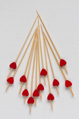 many wooden sticks with red hearts on white background
