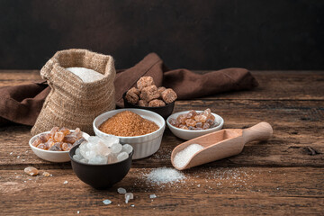 White and cane sugar on a wooden background. Side view with copy space. The concept of a grocery background.